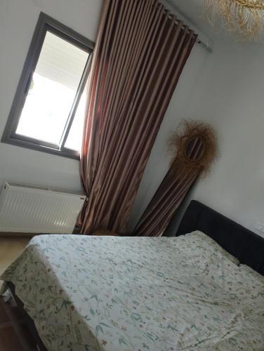 a bedroom with a bed and a window at Appartement num3 Carthage byrsa in Douar ech Chott