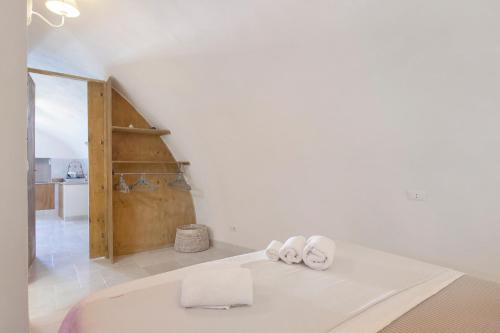 a white room with two towels on a bed at Casa Tuccia in Ostuni
