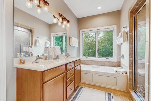 a bathroom with a sink and a tub and a shower at Reserve Your Happy Place in Sugar Mountain