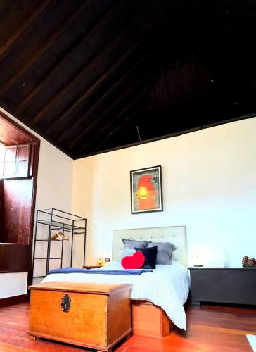 a bedroom with a bed with a wooden chest at Caletn Suites - Charming Farmhouse Retreat in Garachico, Tenerife in Garachico