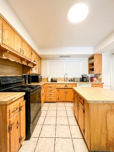 a kitchen with wooden cabinets and a stove top oven at 6BR Pool Escape for Friends and Family - LOU1 - BUR in Burbank