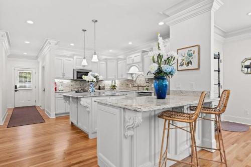 a kitchen with white cabinets and a blue vase of flowers at Luxury Retreat in Red Bank TN in Chattanooga