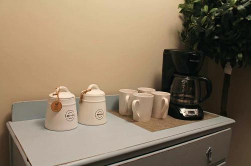 four white coffee cups sitting on top of a counter at Red Bank Cozy Nest in Chattanooga