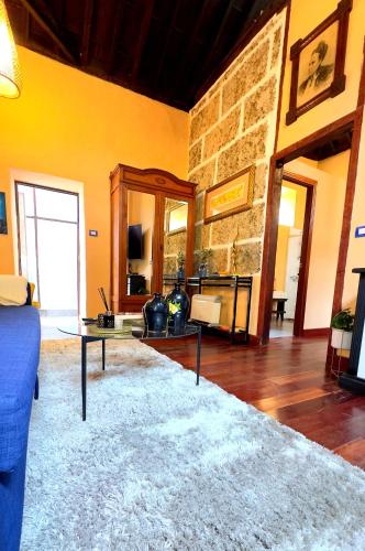 a living room with a table and a stone wall at Caletn Suites - Charming Farmhouse Retreat in Garachico, Tenerife in Garachico