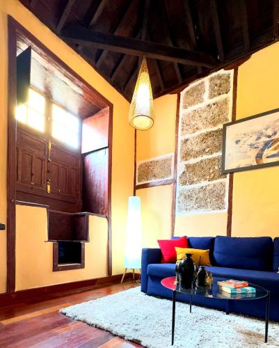 a living room with a blue couch and a table at Caletn Suites - Charming Farmhouse Retreat in Garachico, Tenerife in Garachico