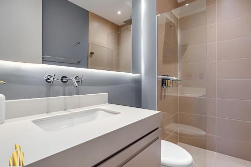 un bagno bianco con lavandino e doccia di Urban 705 - Apto sereno y luminoso con piscina/gym a El Poblado