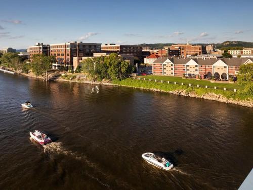 two boats in a river with buildings in the background at Gorgeous apartment across from La Crosse Center in La Crosse