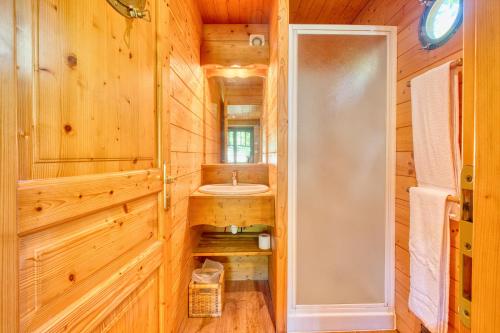 - une salle de bains pourvue d'un lavabo dans une cabine en bois dans l'établissement La Roulotte Rouge, à Monsac