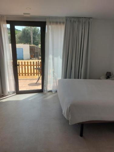 a bedroom with a bed and a sliding glass door at Hotel Nuevo Ondina in Begur