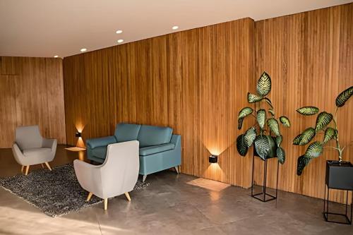 a living room with a blue couch and two chairs at Class 48 apto. 1103 - Estilo loft/vistas panorámicas in Sabaneta