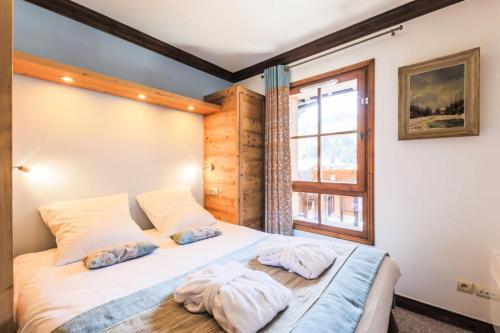 une chambre avec un lit avec deux serviettes dessus dans l'établissement Résidence Les Arcs 1950 Le Village - maeva Home - Appartement 3 pièces 6 personnes Prestige MAE-4069, à Bourg-Saint-Maurice