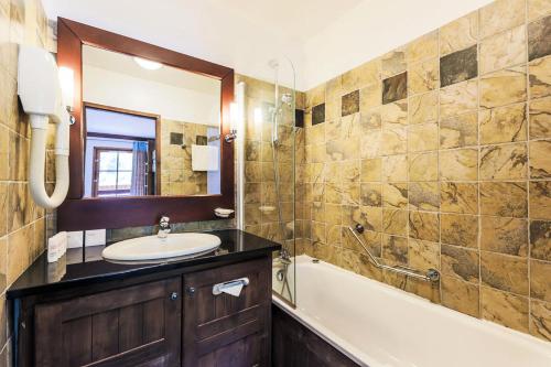 une salle de bain avec une baignoire et un lavabo et une baignoire tubermottermott dans l'établissement Résidence Les Arcs 1950 Le Village - maeva Home - Appartement 3 pièces 6 personnes Prestige MAE-4069, à Bourg-Saint-Maurice