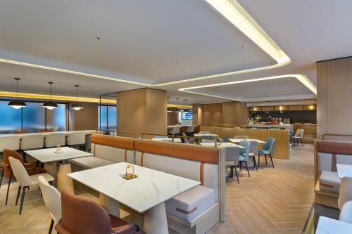 a restaurant with tables and chairs and a bar at Holiday Inn Express Lijiang Ancient Town by IHG in Lijiang