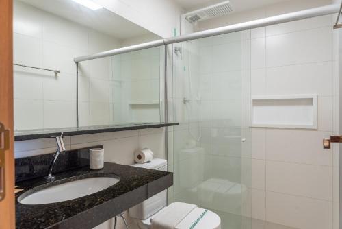 a bathroom with a sink and a glass shower at Studio Design 3 Apt 812 Mandi Hospitalidade in Maceió