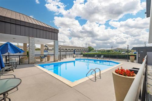 a swimming pool with tables and chairs on a building at Best Western Center Inn in Virginia Beach