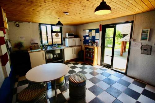 a kitchen with a table and a checkered floor at Cozy Hot Tent with Log Burner & Hot Tub Right Tent in Llanfairpwllgwyngyll