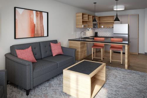 a living room with a couch and a kitchen at Candlewood Suites Orlando North - Winter Park by IHG in Orlando