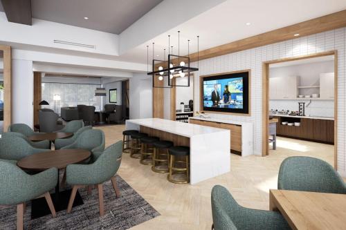 a living room with a kitchen and dining room at Staybridge Suites Williamsville Buffalo by IHG in Williamsville