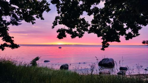a sunset over a lake with rocks in the water at Mereliivatee in Neeme