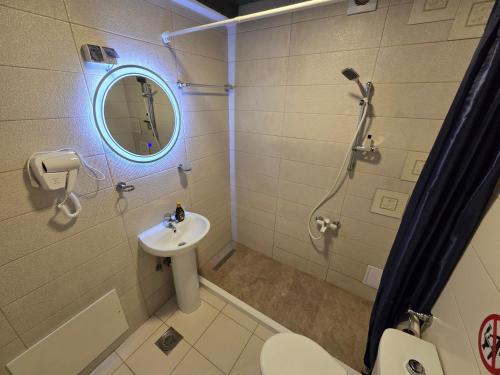 Un baño con lavabo, ducha e inodoro. en Prishtina Central Apartment, en Pristina