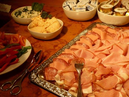 a table with a tray of meat and other foods at Hotel Kohlpeter in Salzburg