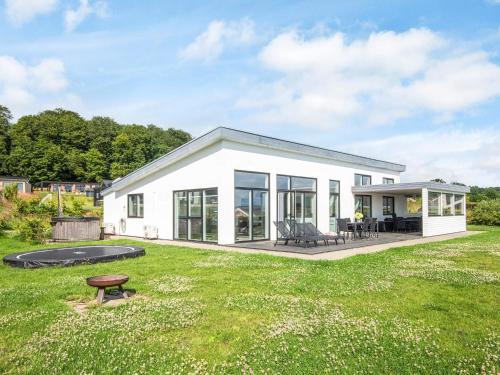 a small white house with a large yard at 10 person holiday home in Sjølund-By Traum in Sjølund
