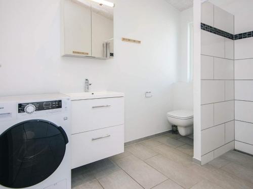 a white bathroom with a sink and a washing machine at 10 person holiday home in Sjølund-By Traum in Sjølund