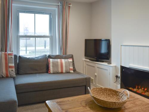 ein Wohnzimmer mit Couch und Kamin in der Unterkunft Coastguard Cottage in Ryde