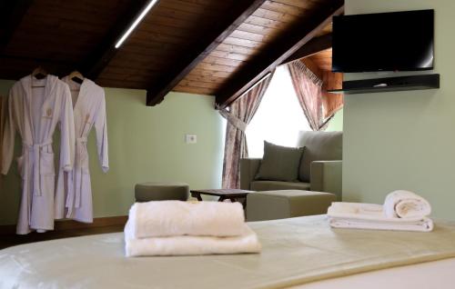 a room with a bed with towels and a tv at Hotel Dusha at Kruja's Mountain in Krujë