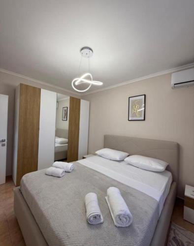 a bedroom with a large bed with towels on it at GLO Apartment in Shkodër