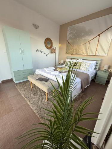 a bedroom with a bed and a potted plant at Aelio Suites- Near Airport and Beach in Markopoulo
