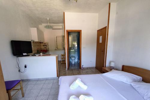 a bedroom with a bed and a kitchen and a television at Apartments by the sea Povlja, Brac - 5644 in Povlja