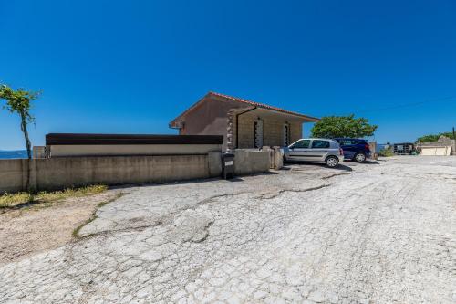 a house with a car parked in a driveway at Family friendly house with a swimming pool Lokva Rogoznica, Omis - 4328 in Lokva Rogoznica
