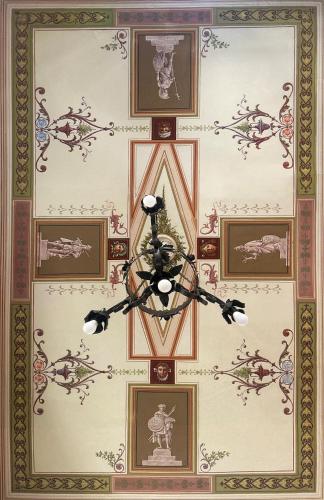 a ceiling with a chandelier and framed pictures at B&B La Fontanina in Siena