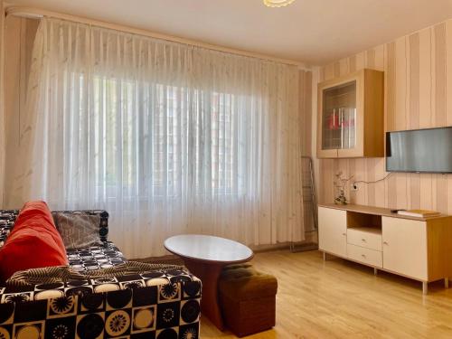 a living room with a couch and a table and a tv at Daina in Ventspils