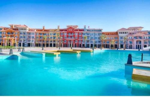 a large pool of blue water with buildings in the background at Elegant Apartments & Aquapark - B&B- FREE WI-FI-Sharm El Sheikh in Sharm El Sheikh