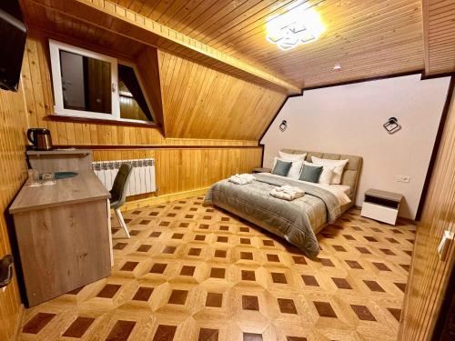 a bedroom with a bed and a desk in a room at Raffaello in Rostoki