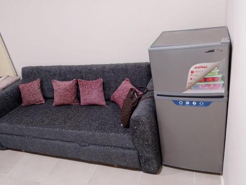 a refrigerator next to a couch with pillows at الغردقه الأحياء منتجع جوليانا بجوار فندق بالم بيتش in Hurghada