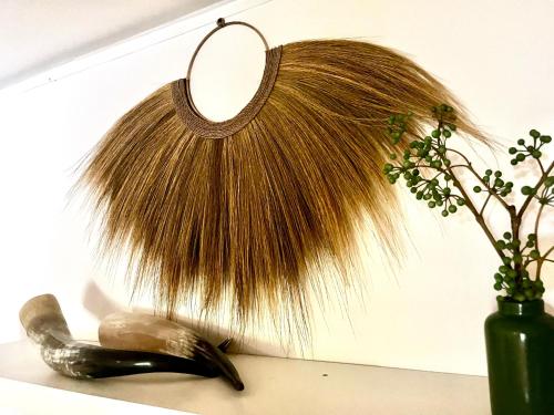 a mirror and a vase on a shelf with a plant at AuxiliumWellness Get Back to Serenity in Grobbendonk