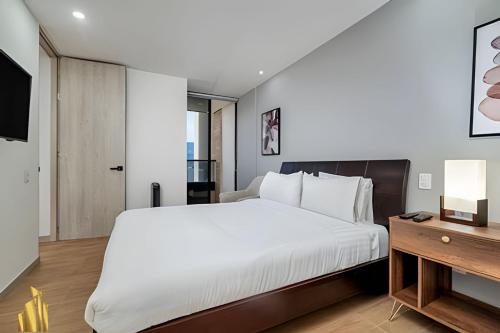 a bedroom with a large white bed and a desk at Class 48 apto. 1303 - Luminoso / Vistas / Balcón in Sabaneta