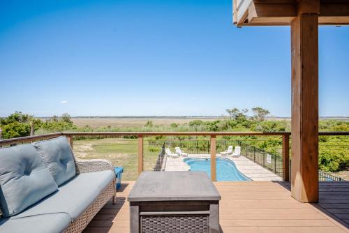 a patio with a couch and a pool on a deck at Lily's Pad in Oak Island