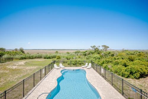 a swimming pool with two lawn chairs and a swimming pool at Lily's Pad in Oak Island