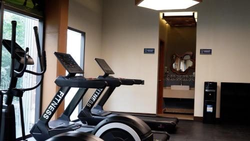 a room with a gym with a treadmill and a mirror at Hotel Mundo Maya Tulum Aeropuerto in Tulum