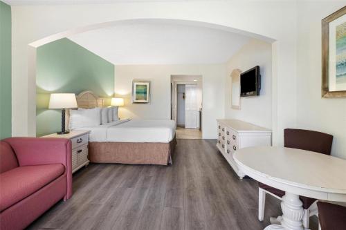 a hotel room with a bed and a couch and a table at Best Western Gateway To The Keys - Florida City, Homestead, Everglades in Florida City