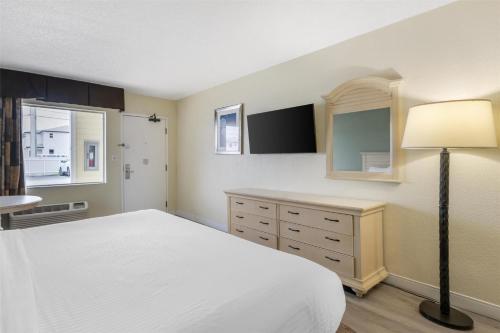 a bedroom with a white bed and a dresser at Best Western Gateway To The Keys - Florida City, Homestead, Everglades in Florida City