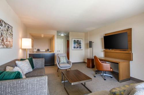 a living room with a couch and a television at Holiday Inn Oxnard - Ventura by IHG in Oxnard