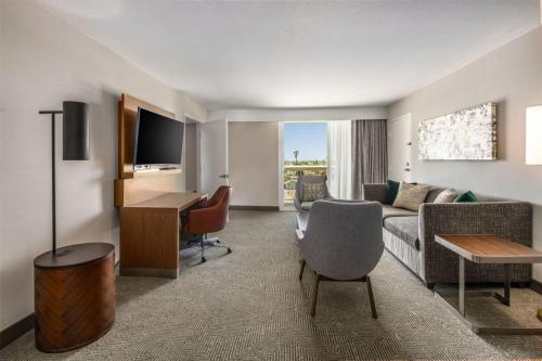 a living room with a couch and a desk in a room at Holiday Inn Oxnard - Ventura by IHG in Oxnard