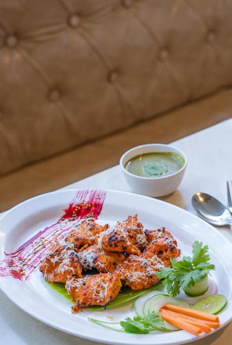 a white plate of food on a table at Hotel Manorama Vijayawada in Vijayawāda