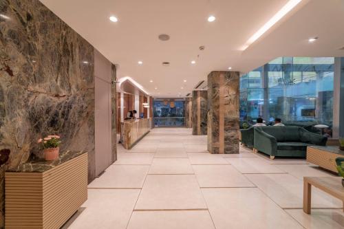 a lobby of a building with a stone wall at Hotel Manorama Vijayawada in Vijayawāda