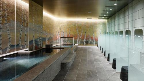 a lobby with a wall with a painting of trees at Holiday Inn & Suites Sapporo Odori Park by IHG in Sapporo